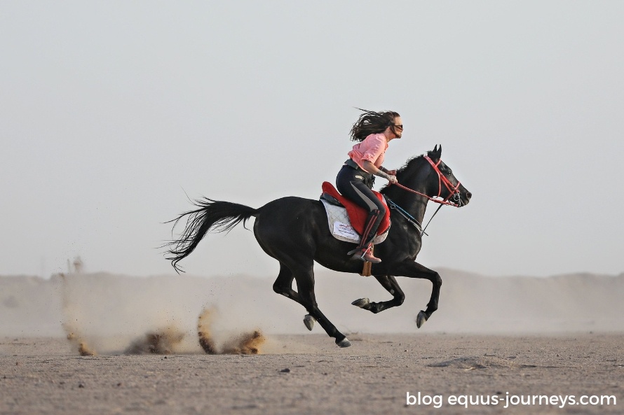 Woman cantering in the desert